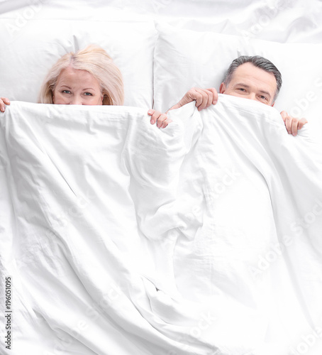 Senior couple hiding under ...