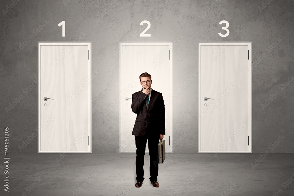Fototapeta premium Businessman thinking in front of three doors
