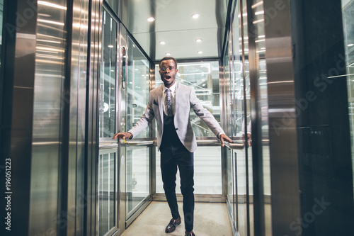african Businessman screaming in the elevator. fear claustrophobia concept