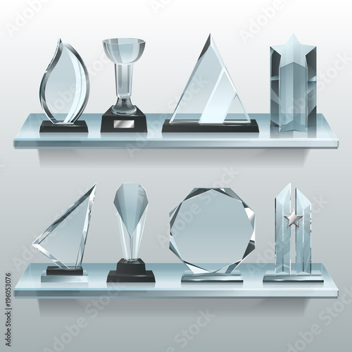 Collections of transparent trophies, awards and winner cups on shelf of glass