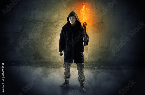 Wayfarer with burning torch in front of crumbly wall concept