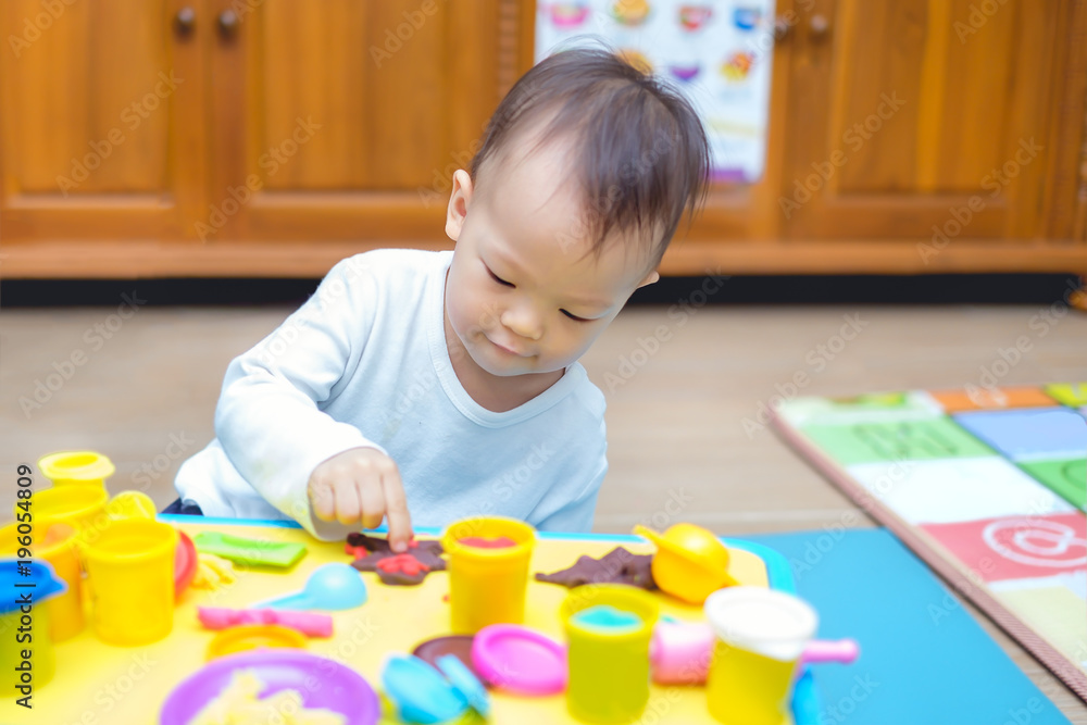 Cute little Asian 18 months old toddler baby boy child having fun playing colorful modeling clay / play dought, cooking toys in play room at home, Educational toys & Creative play for toddlers concept Cute little Asian 18 months old toddler baby boy child having fun playing colorful modeling clay / play dought, cooking toys in play room at home, Educational toys & Creative play for toddlers concept