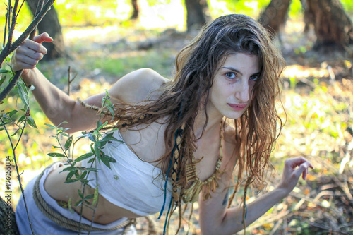 Tableau sur toile Curious pagan girl looking through the branches into the camera