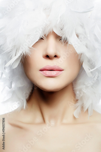 Portrait of Beautiful Girl in white feathers Hat