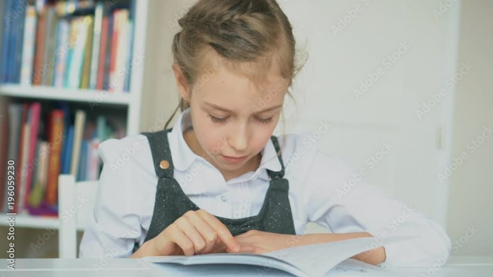 Cute little girl is reading book. Slow motion. Cute little girl is reading book. Slow motion.