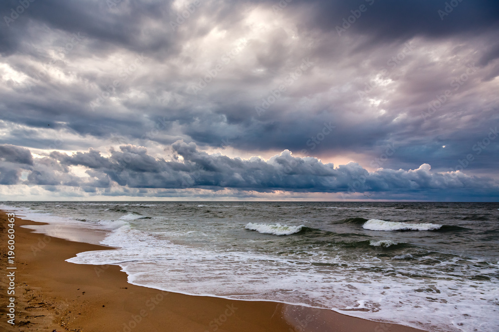 Dramatic sky on a morning seascape. Sunrise on a sandy beach. Dramatic sky on a morning seascape. Sunrise on a sandy beach.