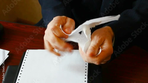 The man emotionally tears paper.