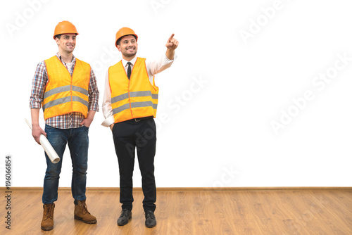 The two engineers gesture on the white wall background