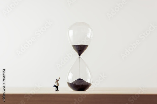 Businessman looking at hourglass. Macro photo
