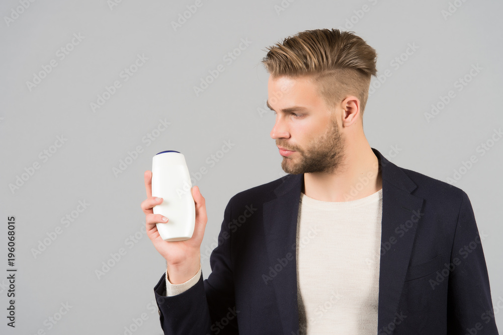 Businessman with shampoo or gel bottle in hand, spa Businessman with shampoo or gel bottle in hand, spa