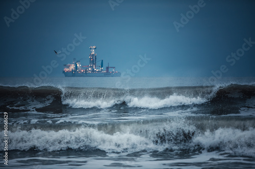 International Container Cargo ship in the sea water after sunset. Freight Transportation, Shipping, Nautical Vessel