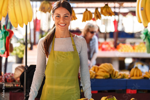 Portrait of young saleswoman on fruit market . photo