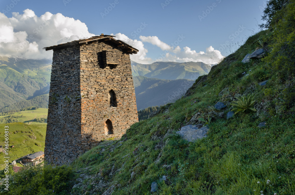 Ruins of traditional Georgian defensive tower at remote Tushetian village Omalo. Tower stands on the steep hill. Lovely summer evening. Ruins of traditional Georgian defensive tower at remote Tushetian village Omalo. Tower stands on the steep hill. Lovely summer evening.