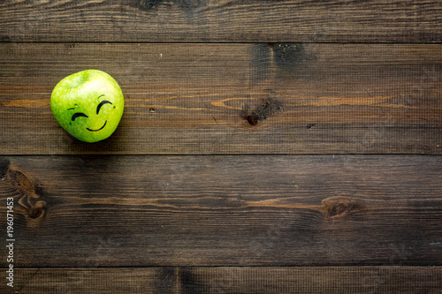 Emotion management concept. Happiness. Face drawn on apple. Wooden background top view copy space