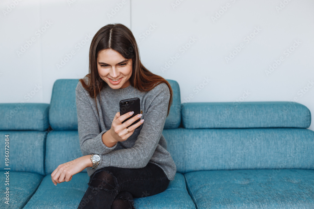 Fototapeta premium girl with smartphone on the sofa