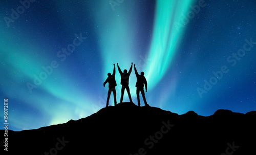 Silhouette of a team on the northen light backgroun. Concept and idea of active life