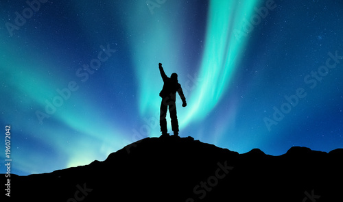 Silhouette of a winner on the northen light backgroun. Concept and idea of active life
