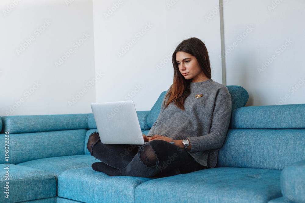 girl with laptop on the sofa and white wall girl with laptop on the sofa and white wall