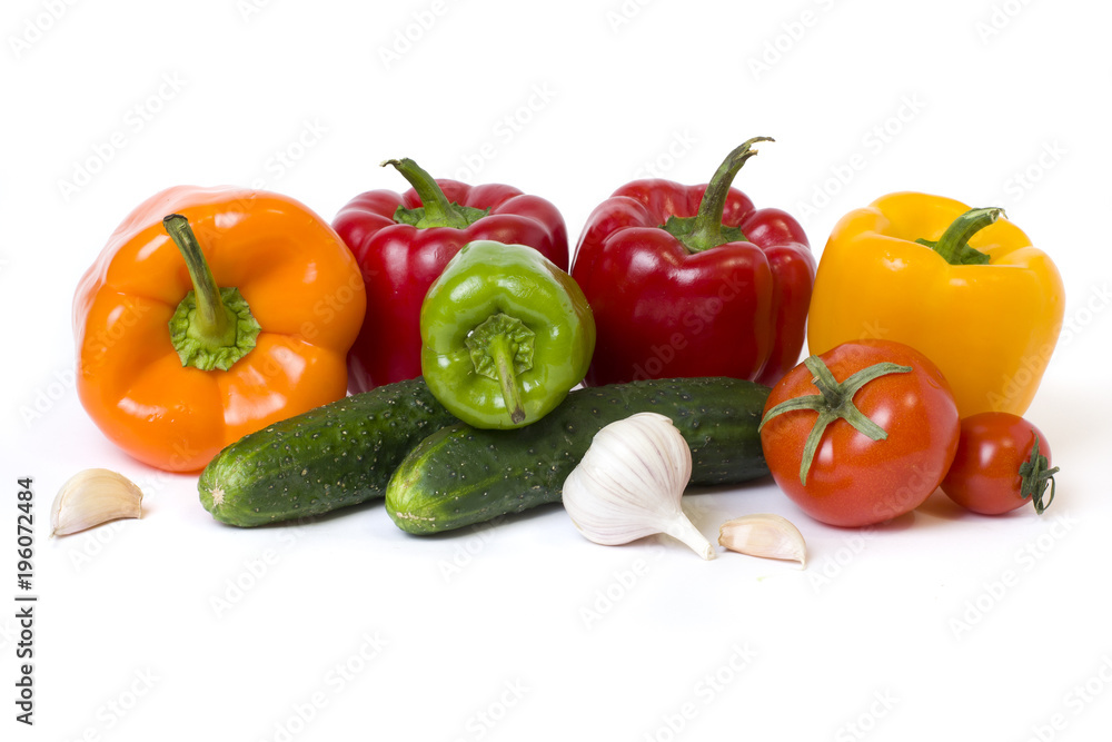 Red yellow and orange peppers with tomatoes on a white background. Cucumbers with colorful peppers in composition on a white background.. Red yellow and orange peppers with tomatoes on a white background. Cucumbers with colorful peppers in composition on a white background..