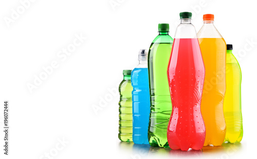 Plastic bottles of assorted carbonated soft drinks over white
