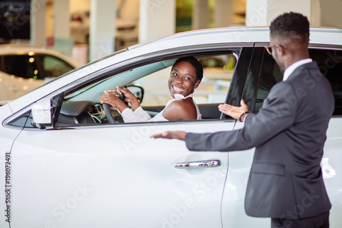 young african woman surprised by new car, gift for my beautiful wife