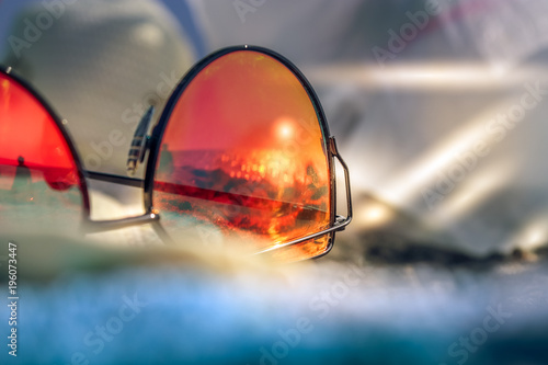 Sunglasses with reflection of summer beach with black sand, sun and sea. Capri Italy