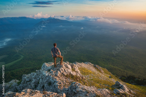 Young man standing on a rocky mountain top