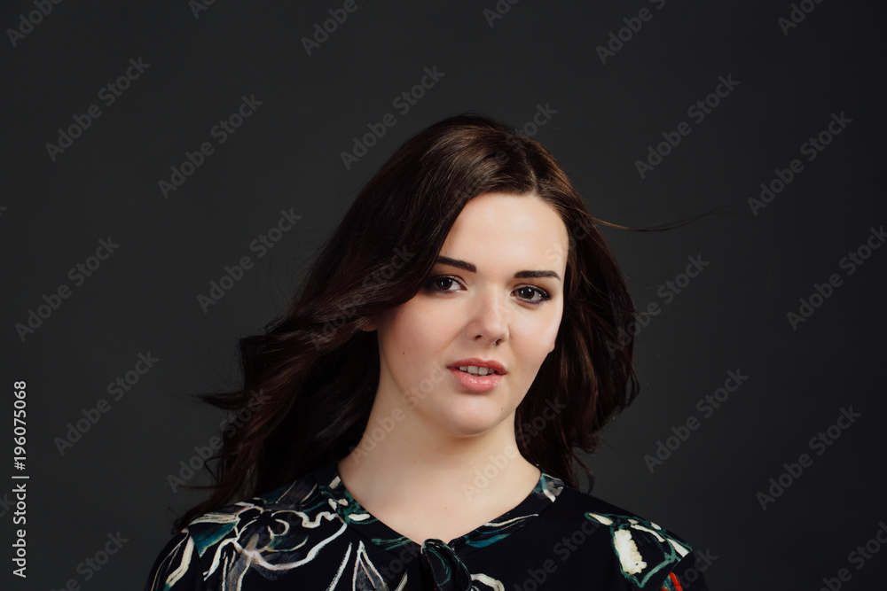 Plus size fashion model in casual dress clothes. fat woman on gray studio background.