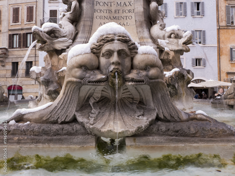 Ein Brunnen in Rom mit schnee auf den Köpfen der Skulpturen