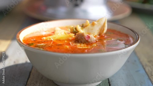 woman eating Thai soup Tom Yam sitting on the beach, 4k slow-motion