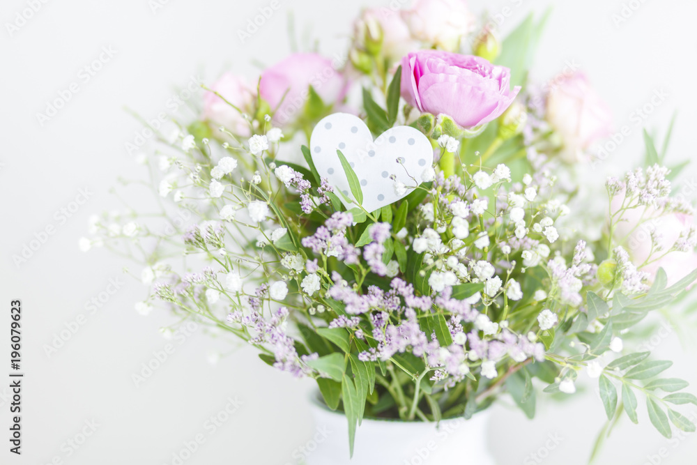 Flowers and flowers - gentle start to spring. Tulips and ranunculus in front of wood background.