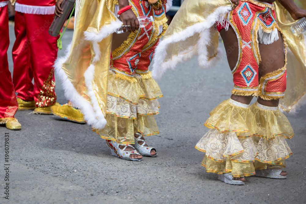 Naklejka premium Woman's legs wearing masquerade mask during carnival parade in Guadeloupe, Caribbean