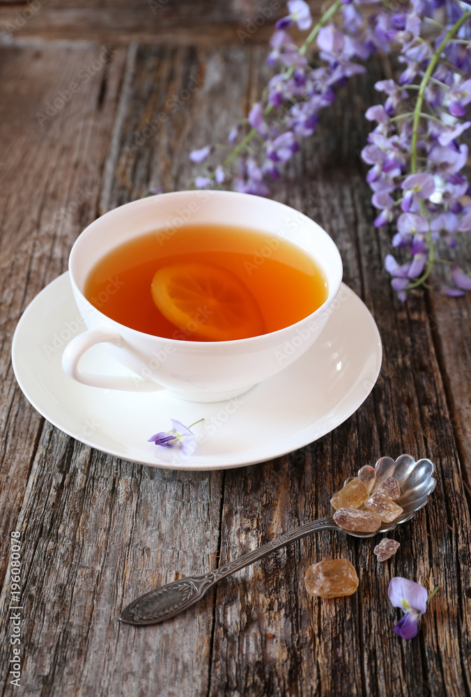 Flowering blue wisteria and cup of lemon tea Flowering blue wisteria and cup of lemon tea