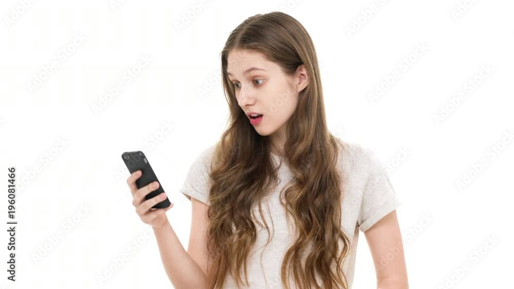 Portrait of young teen woman using smartphone while scrolling social media feed and searching for interesting news, over white background closeup. Concept of emotions Portrait of young teen woman using smartphone while scrolling social media feed and searching for interesting news, over white background closeup. Concept of emotions