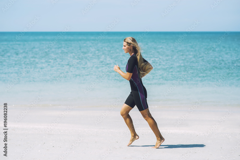 Beautiful woman in wetsuit on the idyllic beach Beautiful woman in wetsuit on the idyllic beach