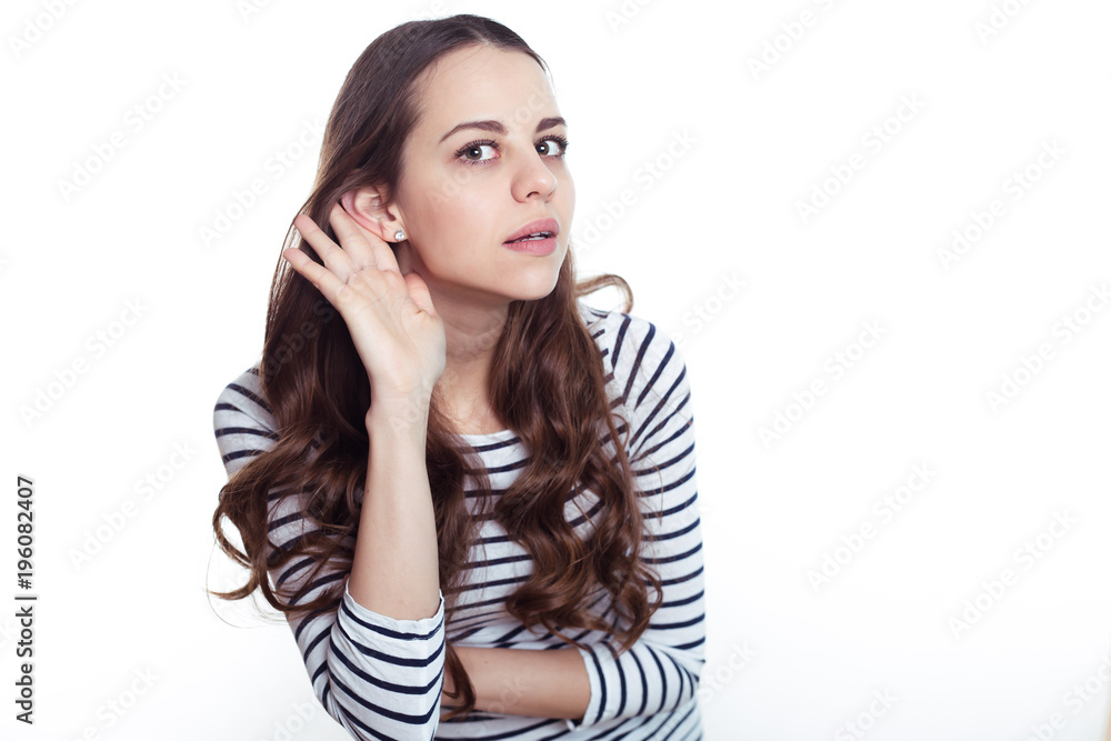 What are you saying? Portrait of a beautiful young smiling modern woman in casual clothes on a white background. What are you saying? Portrait of a beautiful young smiling modern woman in casual clothes on a white background.