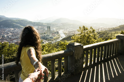 girl hand holding looking an over view of bilbao, in  artxanda a mountain near the city, fly view of bilbao, guggenheim and iberdrola tower  Bilbao, Spain august, 2017