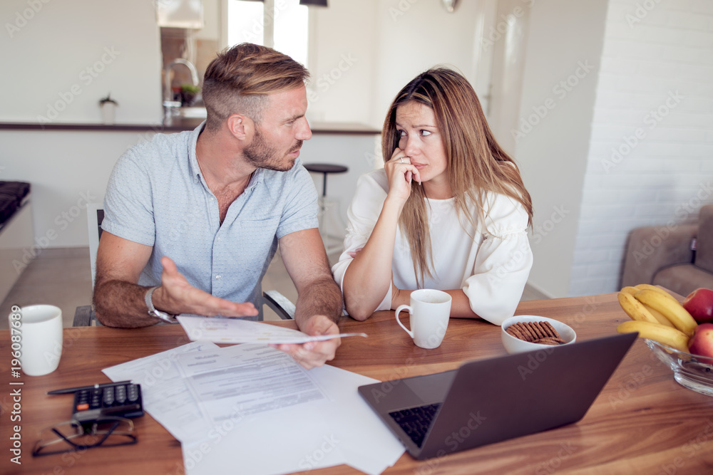 Young couple with accounts and laptop. Young couple with accounts and laptop.