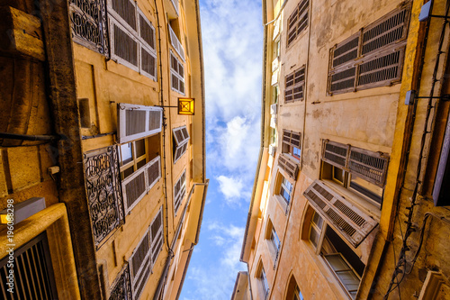 Vue sur les façades des maisons et sur le ciel bleu d'une rue étroite d'Aix-en-Provence. France.