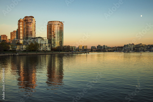 Downtown condos reflecting in the calm waters of False Creek during the golden hour