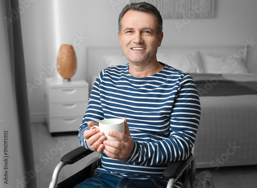 Mature man in wheelchair dr...