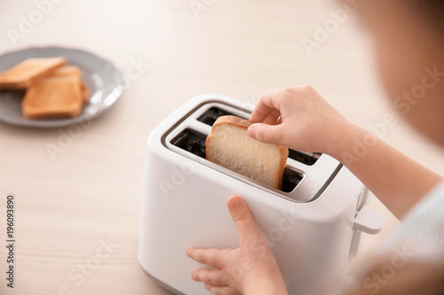 Little girl toasting bread at home