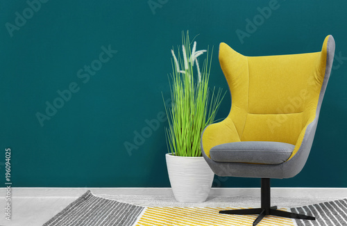 Trendy armchair near shaded...