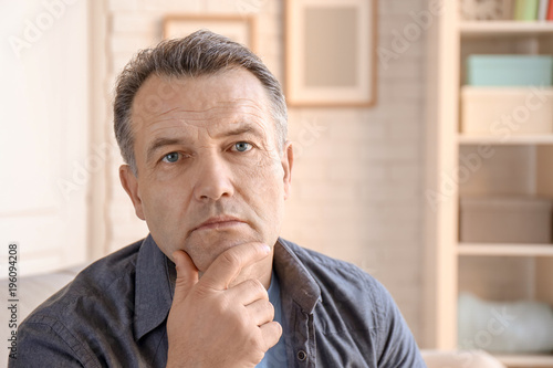 Portrait of serious male pensioner at home