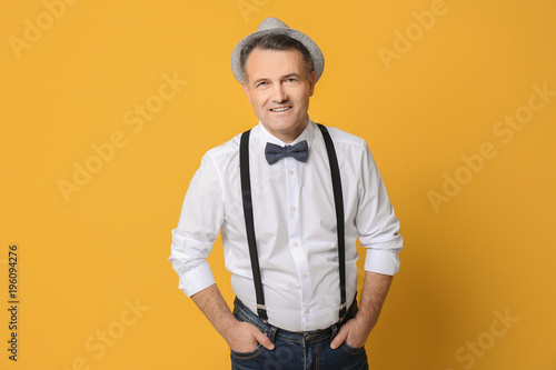 Portrait of stylish male pensioner on color background © Africa Studio