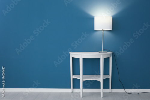 Elegant lamp on table near ...