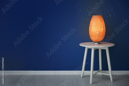 Elegant lamp on table near ...