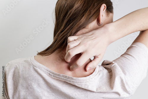 Close up view of woman scratching her neck.