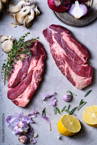 Raw beef steaks, herbs and cooking ingredients, food cooking.