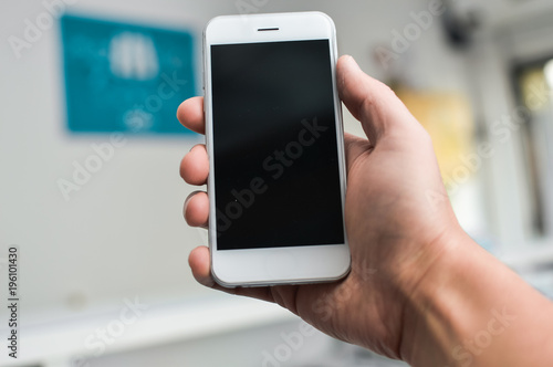 Businessman using mobile phone on light background for photo or video. Writing text, checking calls, reading messages. Close up picture of communication technology device
